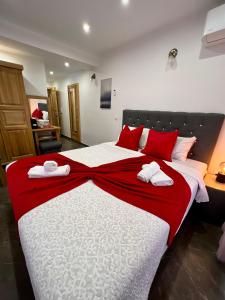 1 dormitorio con 1 cama grande con sábanas rojas y blancas en Rooms Valentino en Liubliana