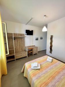 ヴィエステにあるHotel Lido Viesteのベッド1台、薄型テレビが備わる客室です。