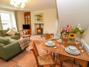 een woonkamer met een tafel en een open haard bij 3 Eden View in Penrith