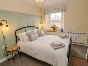 1 dormitorio con 1 cama blanca grande y ventana en 3 Eden View, en Penrith