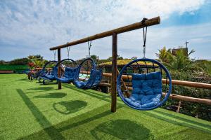 a row of swings in a park at Grajagan Surf Resort in Ilha do Mel