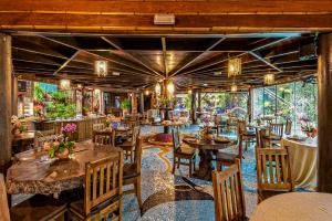a restaurant with wooden tables and chairs and windows at Grajagan Surf Resort in Ilha do Mel