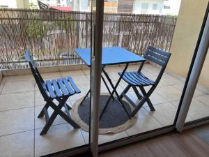 a blue table and two chairs on a balcony at Travel Escape in Cayenne