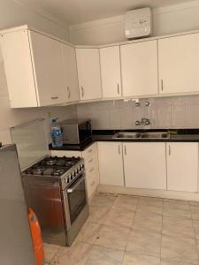 a kitchen with white cabinets and a stove top oven at Appart Hotel Belvedere in Praia