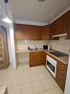 a kitchen with wooden cabinets and a sink at Las Brisas in Granadilla de Abona