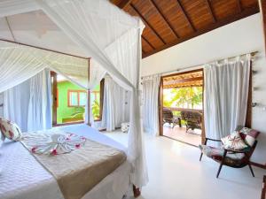 Un dormitorio con una cama grande y un balcón. en Casa Villa Cristian Villa Venezia Pe na Areia, en Arraial d'Ajuda 44 fotos más