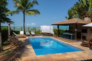 una piscina con sillas y un cenador en Casa Villa Cristian Villa Venezia Pe na Areia, en Arraial d'Ajuda