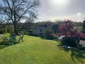 een tuin met twee ligstoelen en een huis bij Broadhaven Cottage, Freshwater East, Pembs in Pembroke
