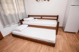 two twin beds in a room with wood floors at VEM para Balneario Camboriu na Praia do Estaleiro in Balneário Camboriú