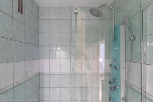 uma casa de banho com um chuveiro e uma cabina de duche em vidro. em ZenBNB - L'émeraude - Beautiful Studio Apartment - Near Tram Station for Geneva em Annemasse