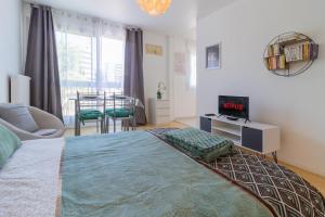 um quarto com uma cama, uma televisão e uma janela em ZenBNB - L'émeraude - Beautiful Studio Apartment - Near Tram Station for Geneva em Annemasse