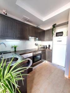 eine Küche mit Holzschränken und einem weißen Kühlschrank in der Unterkunft Deluxe Home from Home in Caleta de Fuste in Caleta de Fuste