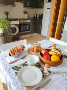 einen Tisch mit einer Schale Obst und Brot darauf in der Unterkunft Deluxe Home from Home in Caleta de Fuste in Caleta de Fuste