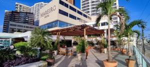 a patio area with tables, chairs and umbrellas at Mareiro Hotel in Fortaleza