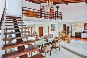 Una sala de estar con una escalera y una mesa y sillas. en Casa Villa Cristian Villa Venezia Pe na Areia, en Arraial d'Ajuda