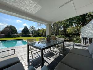 a patio with a table and chairs and a pool at Protea Manor in George