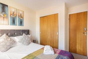een slaapkamer met een bed en een houten deur bij The SUMMIT Apartment - Aberdeen City Centre - Perfect for Long and short Stay in Aberdeen