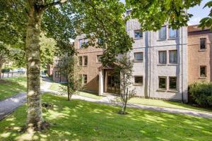 un edificio de apartamentos con un árbol en el patio en The SUMMIT Apartment - Aberdeen City Centre - Perfect for Long and short Stay en Aberdeen