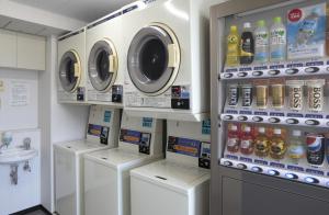 lavadero con lavadoras y fregadero en Nishitetsu Inn Kochi Harimayabashi, en Kochi
