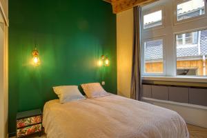 a green bedroom with a bed and a window at Standing, élégance, appartement d'architecte in Lyon