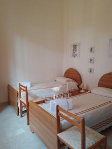 een kamer met drie bedden in een kamer bij L'Albero Amico in Racalmuto