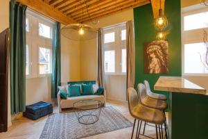 a living room with green walls and a table and chairs at Standing, élégance, appartement d'architecte in Lyon