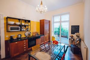 ウィーンにあるLeuhusen Boutique Apartments Vienna, Wienのガラスのテーブル付きのキッチンが備わる客室です。