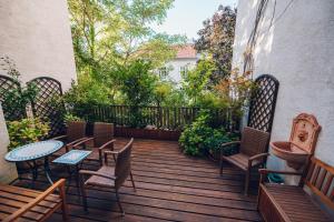 una terraza de madera con sillas, mesas y una valla en Leuhusen Boutique Apartments Vienna, en Viena