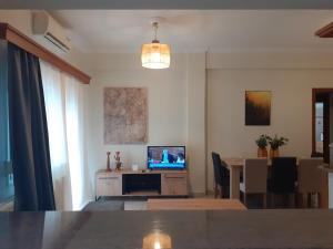 - un salon avec une télévision et une table à manger dans l'établissement Spacious Apartment in Athens center Sepolia near two metro and train stations, à Athènes