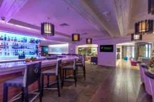 紐奧良的住宿－新奧爾良市區超圓屋頂體育場假日酒店，餐厅内的酒吧拥有紫色的灯光