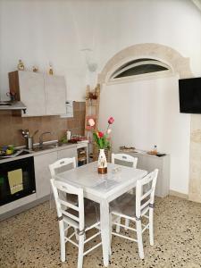 una cucina con tavolo bianco e sedie bianche di La dépendance a Fasano