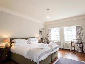 a bedroom with a large bed with white sheets at Inverewe - House Apartment in Achnasheen