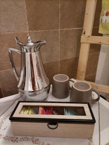 un bollitore per tè d'argento e due tazze su un tavolo di La dépendance a Fasano