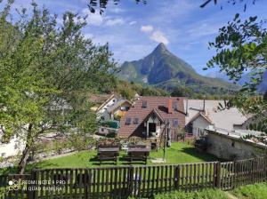 a house with a fence and a mountain in the background at ODAI in Bovec