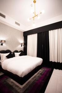 a bedroom with a large bed with a black headboard at Hotel Philosophy in Amman