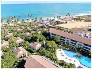 an aerial view of a resort with a pool and the ocean at Apartamento Beira mar Praia dos Caneiros in Tamandaré