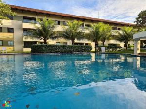 a large swimming pool in front of a building at Apartamento Beira mar Praia dos Caneiros in Tamandaré