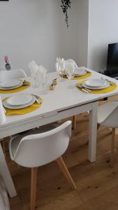 a white table with yellow plates and glasses on it at *Street Clichy Art* - Appartement à 200 m de Paris ! in Clichy