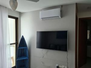 TV de pantalla plana colgada en la pared en Apartamento Beira mar Praia dos Caneiros en Tamandaré