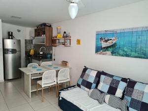 uma sala de estar com um sofá, uma mesa e uma cozinha em Apartamento Beira mar Praia dos Caneiros em Tamandaré