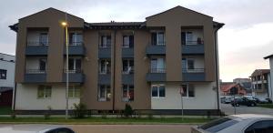 a large apartment building with balconies and a parking lot at Apartament Vila Brana Sibiu Selimbar str Nicolae Brana Nr 63 Ap 4 in Şelimbăr