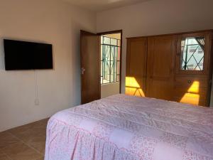 a bedroom with a bed and a flat screen tv at Casa del Zocalo in Tlatlauquitepec
