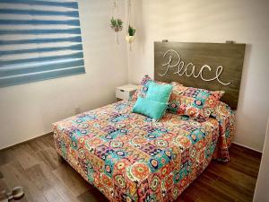 1 dormitorio con 1 cama con un edredón colorido en Zona Andares Con Sala De Cine Privada¡¡¡, en Guadalajara