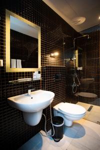 a bathroom with a sink and a toilet and a mirror at Hotel Philosophy in Amman