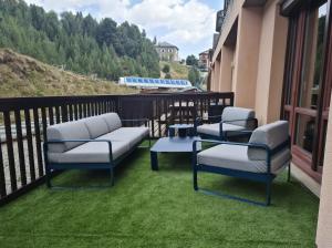 three chairs and a table on a balcony at Cocoonabay Appartements in Les Angles