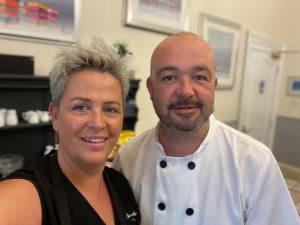 a man and a woman standing in a kitchen at Cherwood Guest House in Paignton