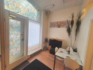 ein Wohnzimmer mit einem Tisch, Stühlen und Buntglasfenstern in der Unterkunft Center of Helsinki 1 in Helsinki