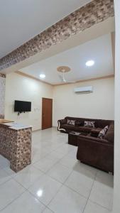 a living room with couches and a flat screen tv at AL Ibdaa Compound Furnished Apartments in Baish
