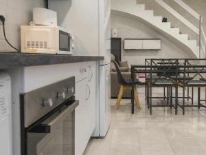 cocina con microondas y mesa con sillas en La casita del caracol by Toledo AP, en Toledo