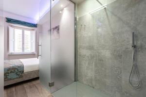 a bathroom with a glass shower with a bed at La Romantica camere e wellness in Senigallia